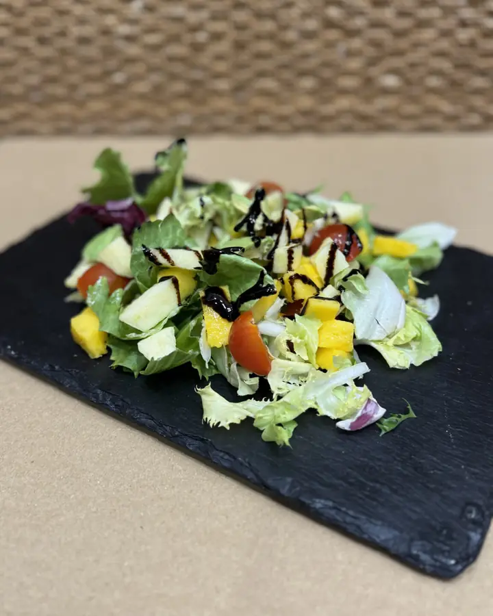 Ensalada de lechugas y verduras sobre pizarra