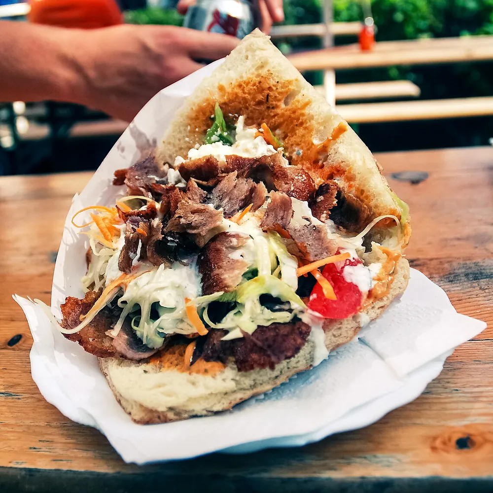 Bocadillo de gyros con la carne en tiras, lechuga, tomate y salsa (foto ilustrativa)