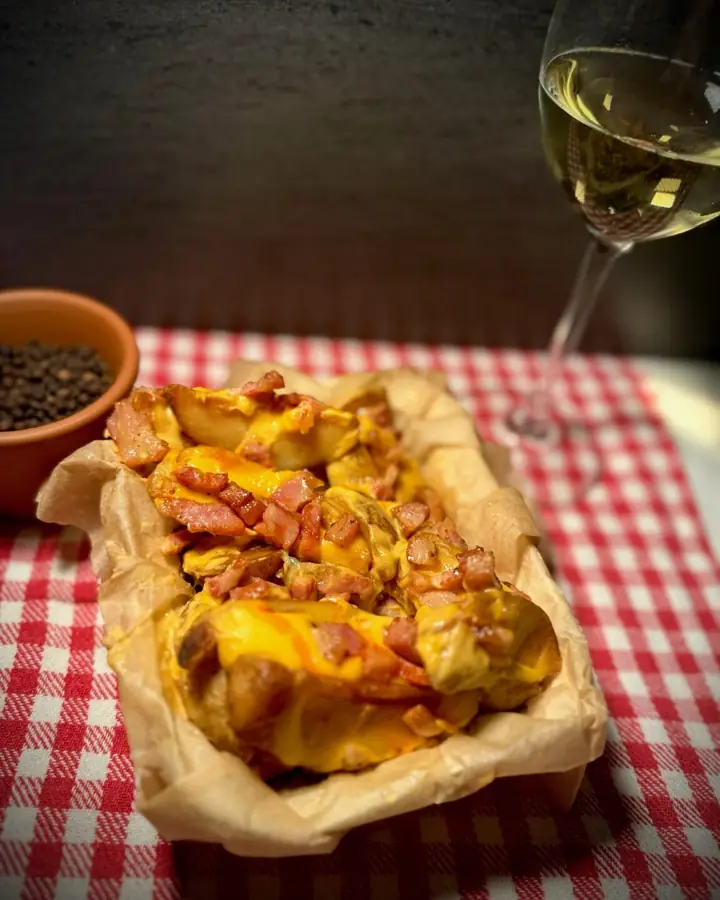 Barqueta de pan gratinada sobre mantel de cuadros