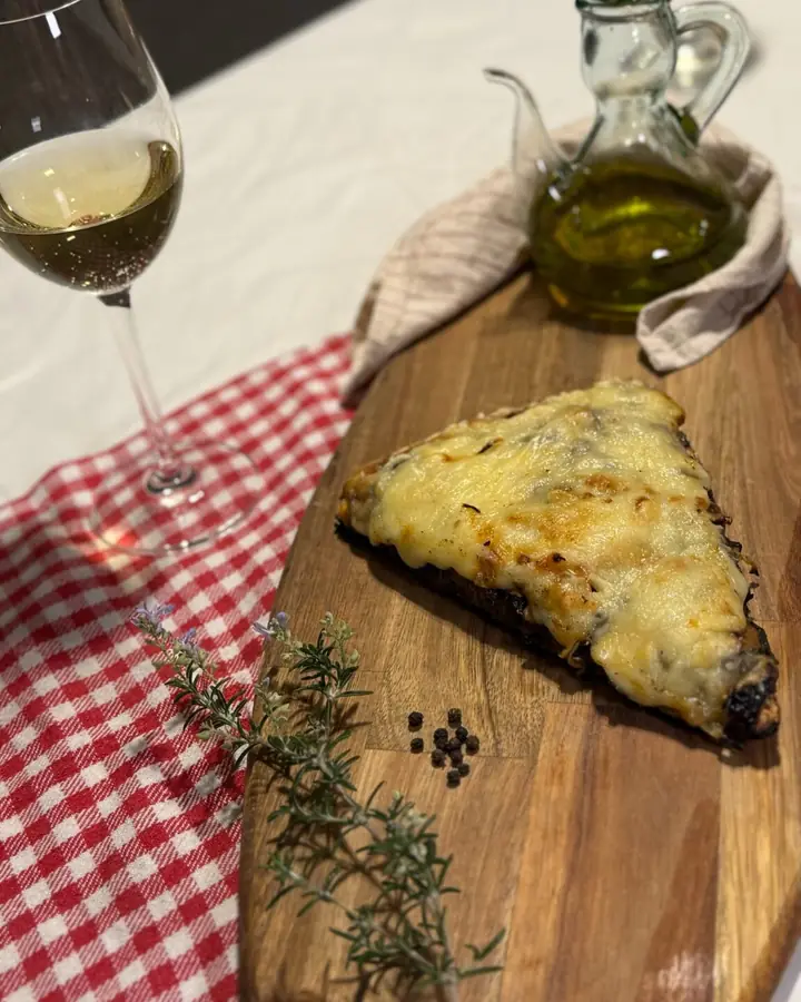 Porción gratinada sobre tabla de madera
